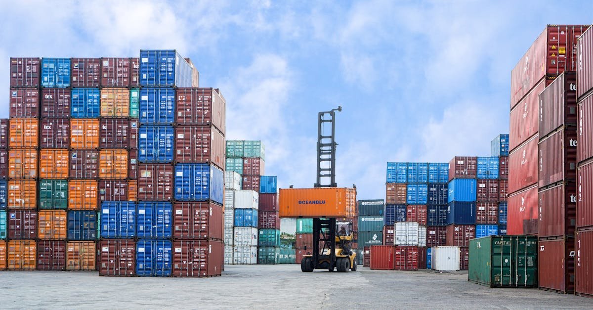 Colorful shipping containers and forklift in a busy Jakarta port under blue skies.