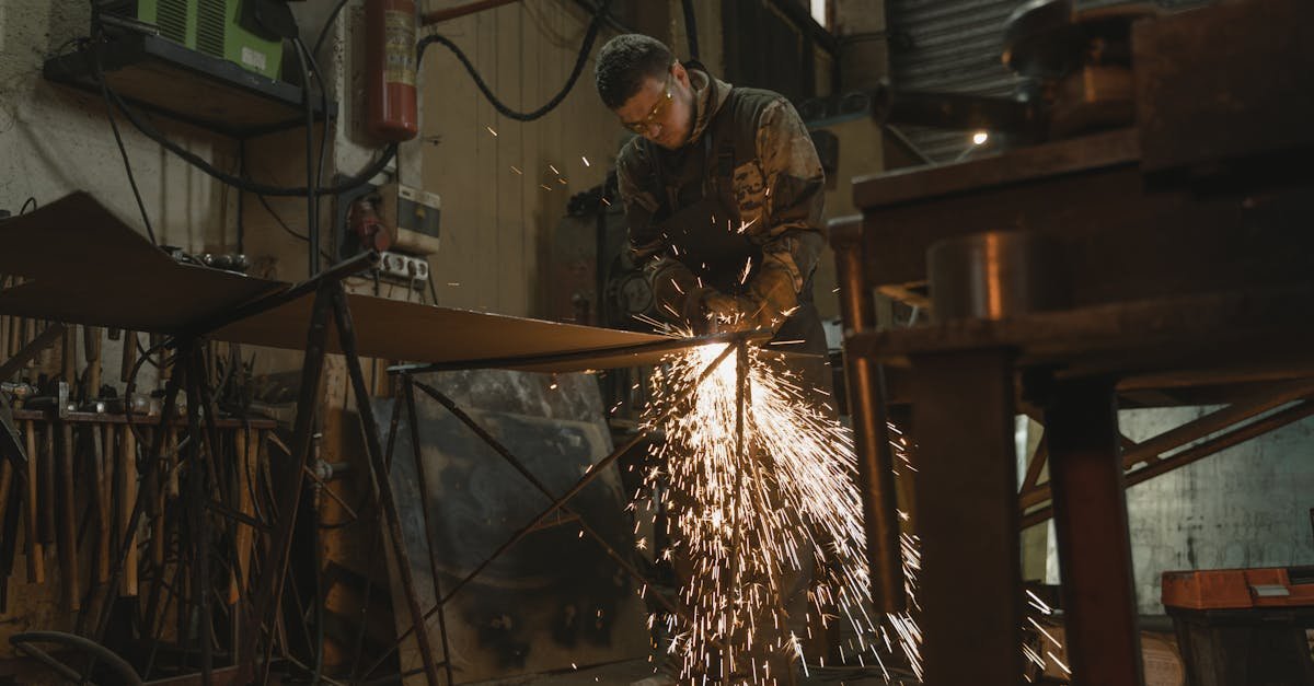 Male welder in safety gear welding metal with sparks in an industrial setting.